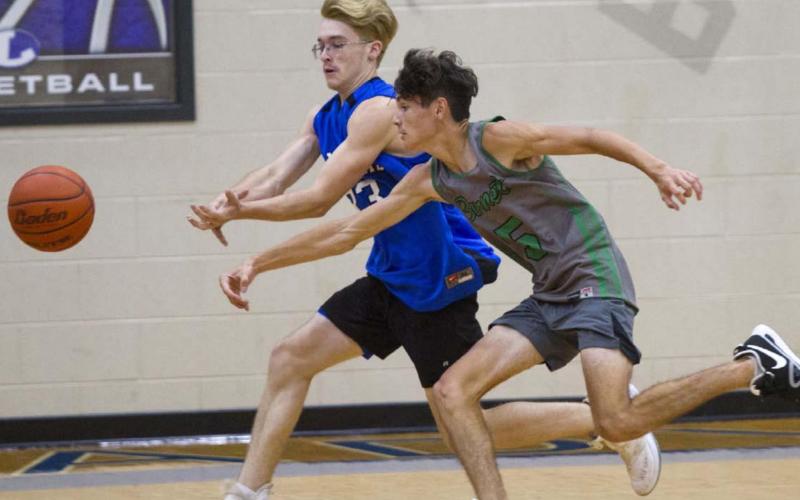 Cort Howard, left, and an opposing player race to the ball near the corner of the court in a recent game. JEFF LOWE | DISPATCH RECORD