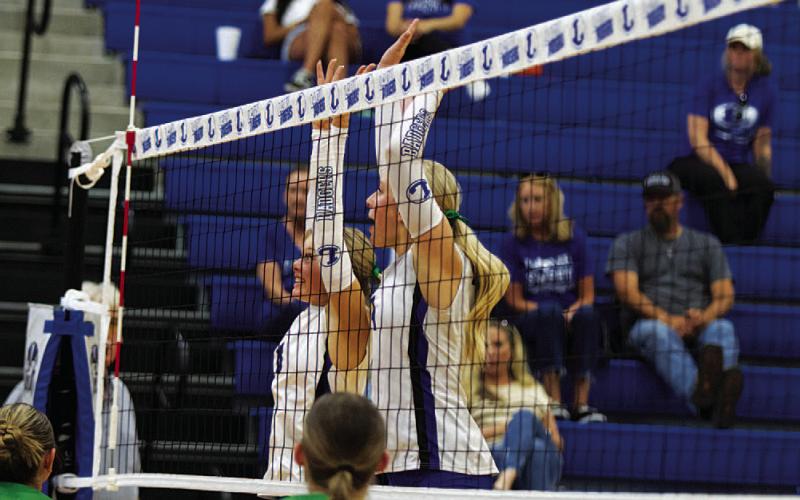 Scout Barton, left, and Brylie Turner jump for a block in their match against Burnet. HUNTER KING | DISPATCH RECORD