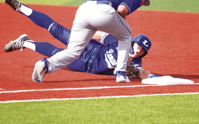 HUNTER KING | DISPATCH RECORD Rawlin Smith dives back into first base after a pickoff attempt during last week’s game.