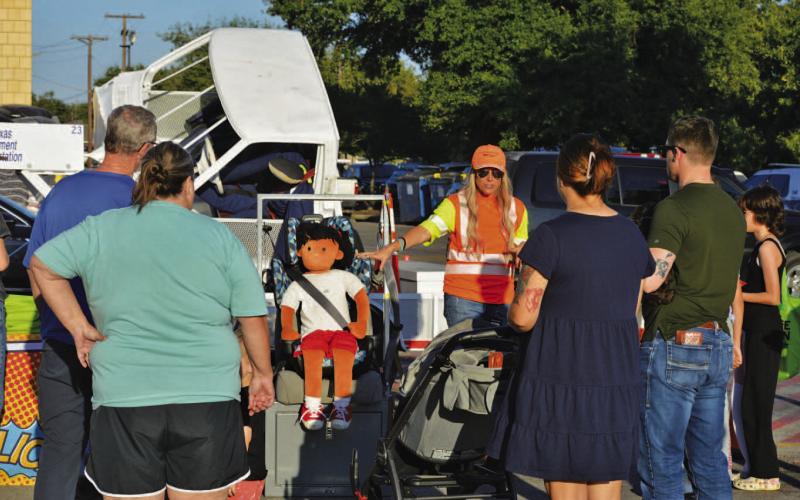 Lampasas residents receive instruction from Texas Department of Transportation staff during Tuesday’s National Night Out on the importance of child safety seat usage and ensuring young passengers are correctly strapped in while riding in a vehicle. ERICK MITCHELL | DISPATCH RECORD