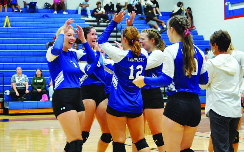 The Lady Badgers celebrate after Temple called a timeout during Tuesday’s match on the road.
