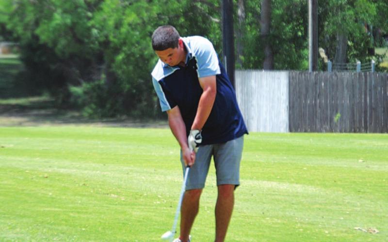 Shane Cazas makes contact with his approach shot on the fifth hole on Friday. HUNTER KING | DISPATCH RECORD