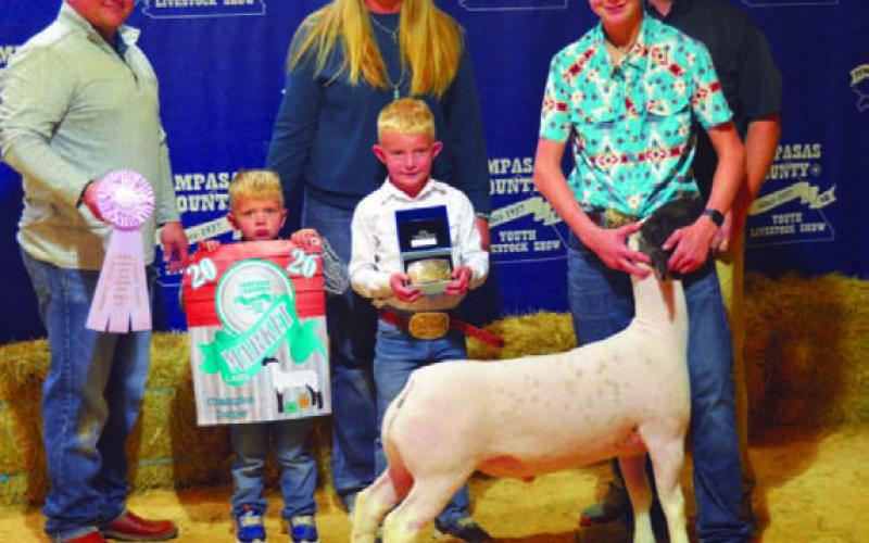 Hadley Kuhl and family display his awards after he earned reserve champion show honors with his Dorper lamb. ERICK MITCHELL | DISPATCH RECORD