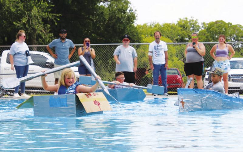 At left, Sarah Wertz takes the lead in the race during Saturday’s Spring Ho Cardboard Regatta. CHLOE COWDREY | DISPATCH RECORD
