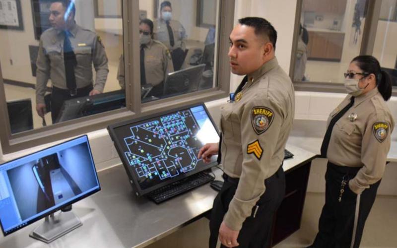 Lampasas County Sheriff’s Office Sgt. John Reza, left, monitors one of the jail’s security cameras as Detention Officer Elaine Tobar looks on. MONIQUE BRAND | DISPATCH RECORD