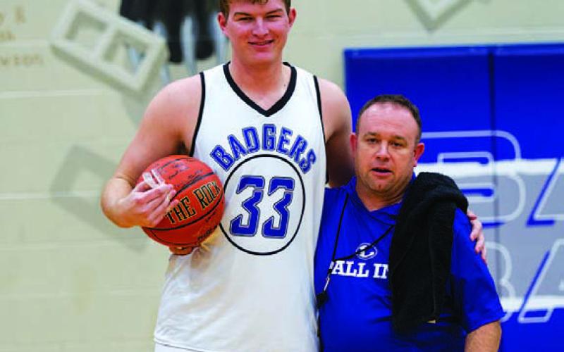 HUNTER KING | DISPATCH RECORD Beau Patterson (left) received a basketball signed by all of his teammates from head coach Aaron Nuckles during practice on Monday after they celebrated Patterson scoring his 1,000th career point prior to the Thanksgiving break.