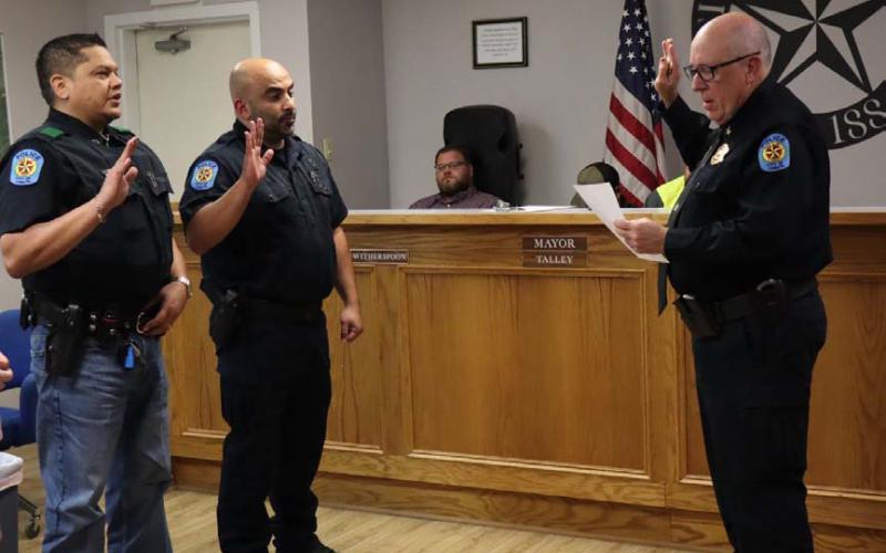 Lometa Police Chief Ronnie Strain swears in the police department’s newest officers. Jose Velazquez, at left, and Morrad Yasin, center, are now patrolling Lometa’s streets and serving the residents. CHERI JAY-WIENECKE | DISPATCH RECORD
