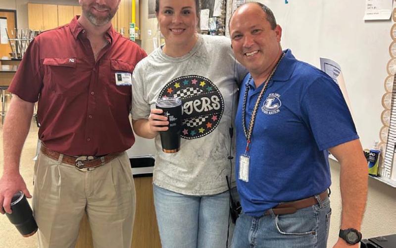 Chandler Hail, center, was selected September Teacher of the Month. Administrators said the science teacher is tough but fun in the classroom, and she continues this love and high standards as a coach on the volleyball and basketball court. Clay Phillips, left, of Texas Farm Bureau Insurance was on hand for the recognition, along with Principal Paul Weinheimer. courtesy photo