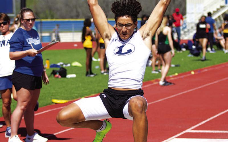 HUNTER KING | DISPATCH RECORD Ty Johnson leaps into the sand during the long jump at last Thursday’s home track meet.