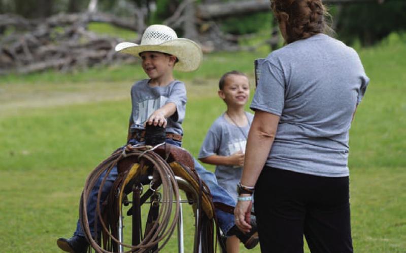 Kyler Harrell embraces his inner cowboy and climbs atop a saddle. ERICK MITCHELL | DISPATCH RECORD