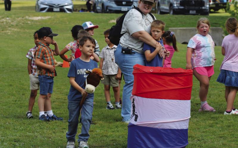 ERICK MITCHELL | DISPATCH RECORD Orion Vantassell avoids a barrel while riding his toy horse during Ag Day activities.