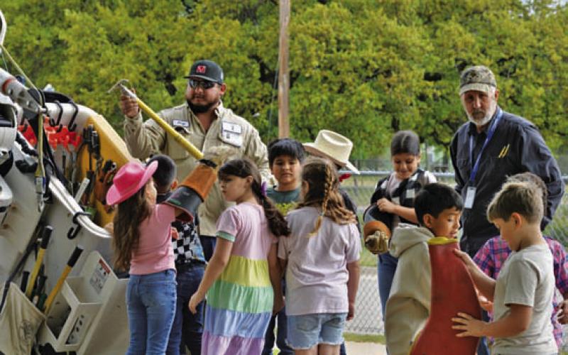 ERICK MITCHELL | DISPATCH RECORD Hamilton County Electric Cooperative employees engaged with students during Ag Day at Hanna Springs Elementary School.