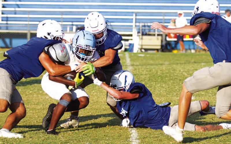 HUNTER KING | DISPATCH RECORD A group of Badgers are in on the tackle of the China Spring ball carrier.