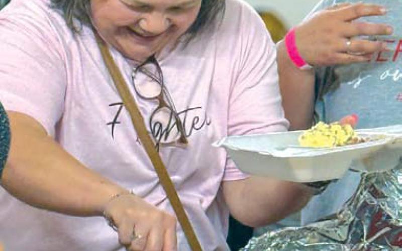Teresa Sanchez serves food at the event held to benefit her cancer treatment. courtesy photo