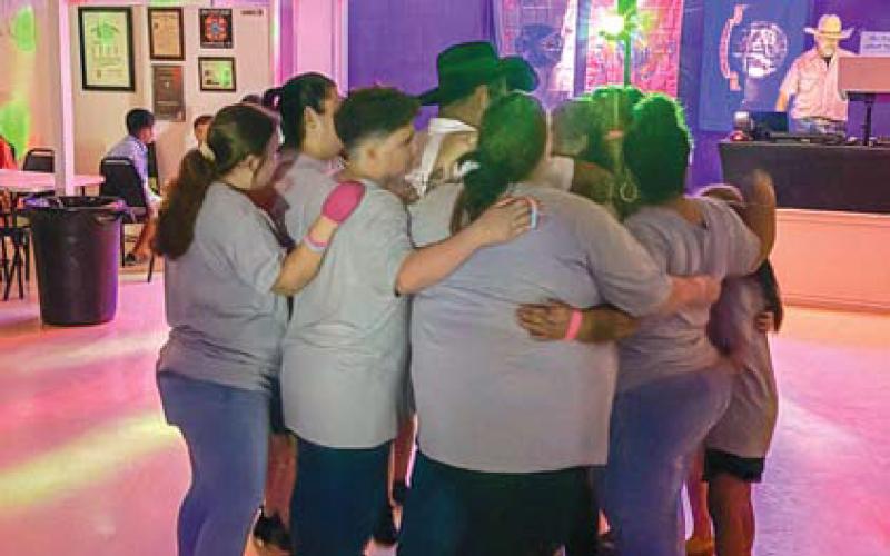 Family and friends gather around Teresa Sanchez, a Lampasas mom with a cancer diagnosis, during a benefit held for her on June 28. courtesy photo