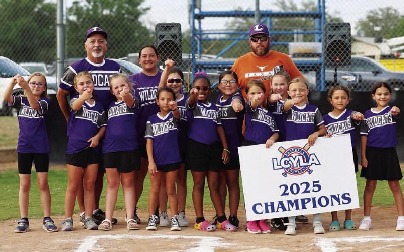 COURTESY PHOTO A young softball team shows off their rings from winning last season.