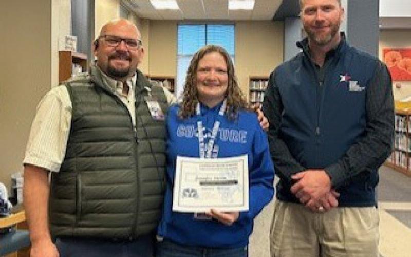 Interventionist Jennifer Storm was recognized as a Staff of the Month for January at the high school. Assistant Principal Ryan Race, at left, said Storm’s students have over a 90% pass rate, and she always has a smile on her face. Clay Phillips, of Texas Farm Bureau Insurance, is pictured with her. Courtesy photo