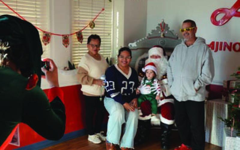 ERICK MITCHELL | DISPATCH RECORD Santa Claus made the trip from the North Pole to meet with children and families at Ajinomoto Foods on the square.