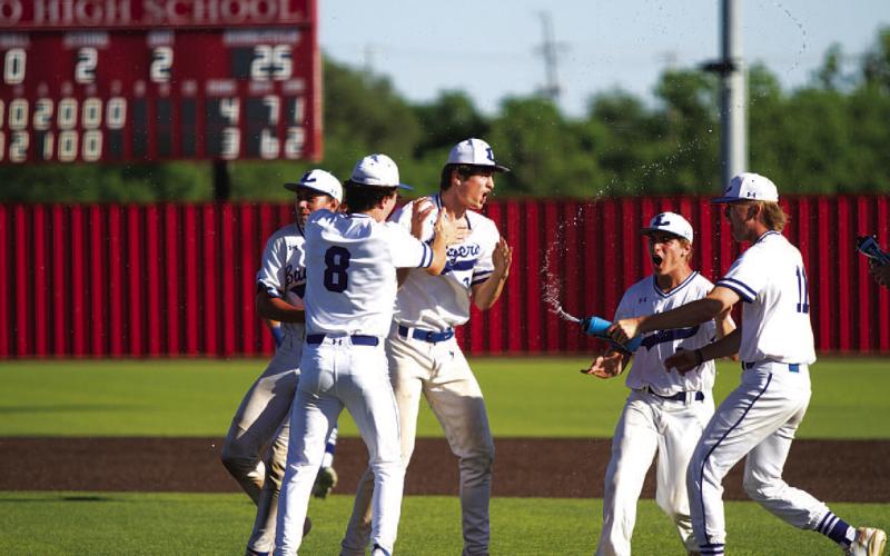 HUNTER KING | DISPATCH RECORD Mitchell is surrounded by his teammates after the Badgers won the bi-district playoff round.
