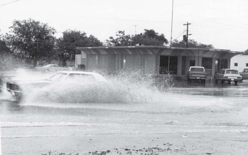 A car passes through the flooded roadway at Key Avenue and Seventh Street. A low-water crossing was created across Key Avenue at this intersection in the 1950s to channel runoff from the west side of the roadway. lampasas dispatch record, April 1971