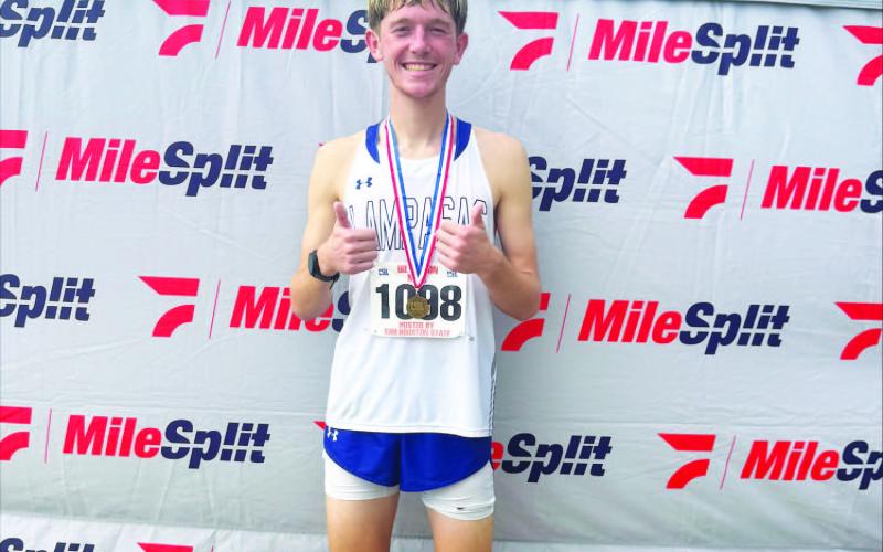 COURTESY PHOTO | KIM BURNSIDE John Keyes poses with his medal after finishing 10th at the regional cross country meet and qualifying for state.