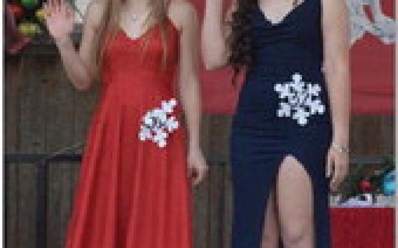 ERICK MITCHELL | DISPATCH RECORD Kara Burnett, at left, and Brittany Martinez wave to the crowd. Martinez was crowned the high school Snow Queen, while Burnett earned the title of Princess.