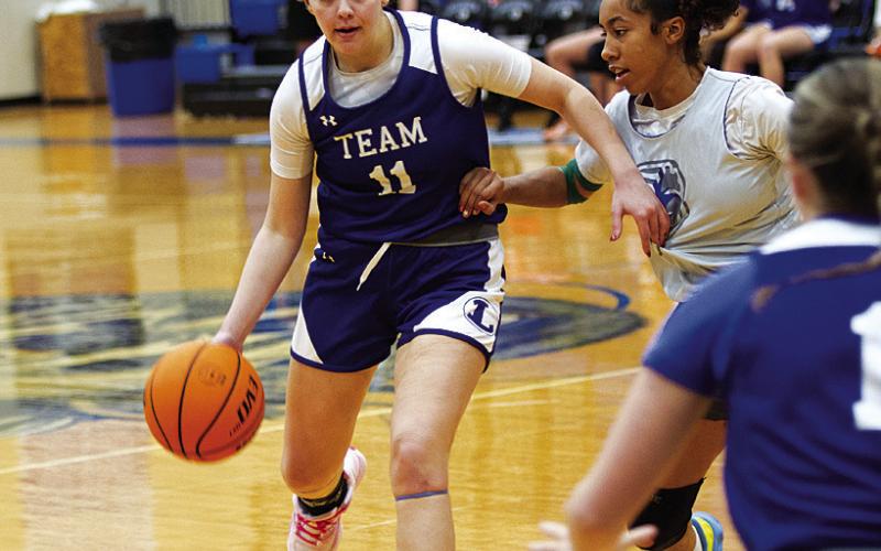 Mia Mulcahy dribbles over to pass to a teammate during the girls’ basketball scrimmage Tuesday. HUNTER KING | DISPATCH RECORD