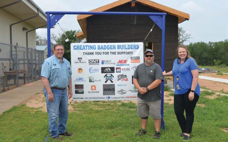 Creating Badger Builders President Herb Pearce, at left, stands with high school construction teacher Richard Silva-Brown and CTE Director Liz Haviland by a sign recognizing the project sponsors. erick mitchell | dispatch record