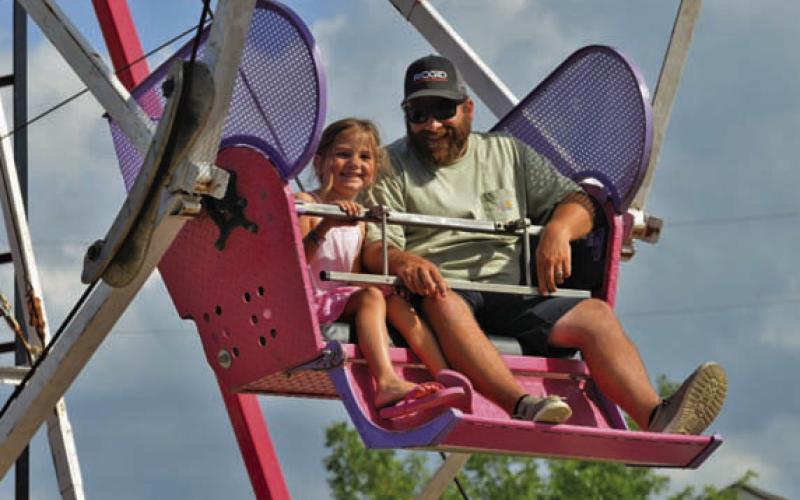 Out-of-town visitors, from left, Elizbeth and Hunter Ranspot enjoy a ride on the Ferris wheel. ERICK MITCHELL | DISPATCH RECORD