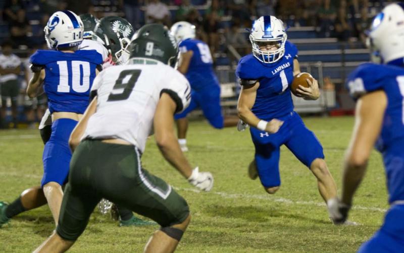 HUNTER KING | DISPATCH RECORD Luke Smith looks for a hole to run through as his blockers create space during the win over the Taylor Ducks last Friday.