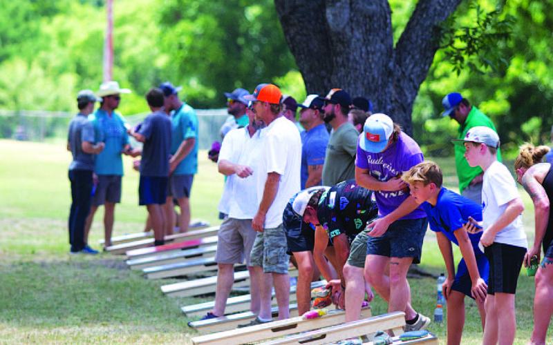 HUNTER KING | DISPATCH RECORD Tournament participants toss bags during Saturday’s cornhole competition.