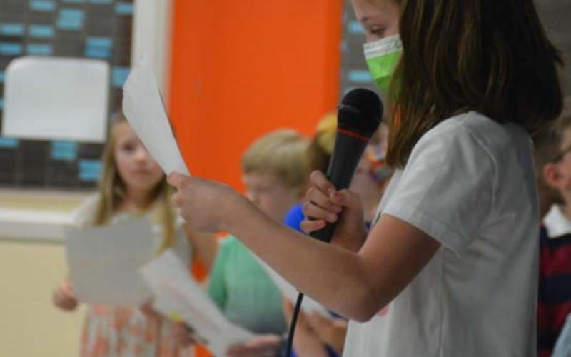 Arion Michaud, 9, recites her poem about dolphins during Taylor Creek Elementary School’s poetry café event Friday. MONIQUE BRAND | DISPATCH RECORD
