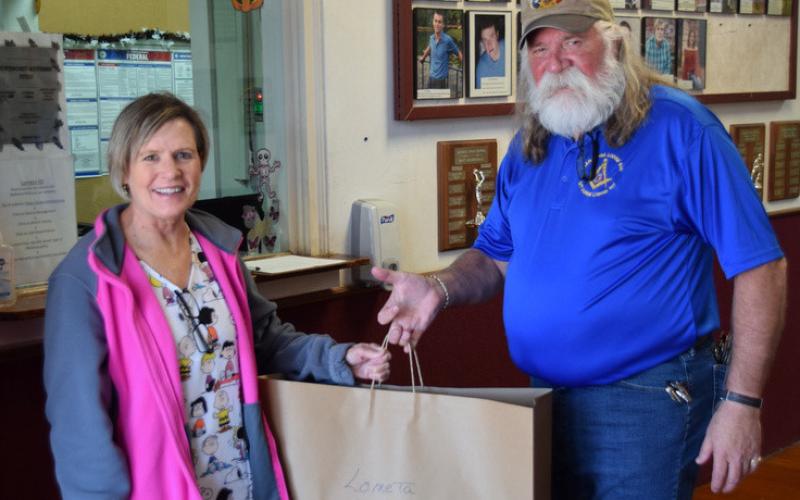 Lometa School nurse Monica Ivey, RN, accepts tooth decay prevention kits from Guy Niles, representing Saratoga Lodge #546. The Fantastic Teeth kits are designed to provide dental education to first-grade students and their parents. courtesy photo | Dorton Q. Matthews
