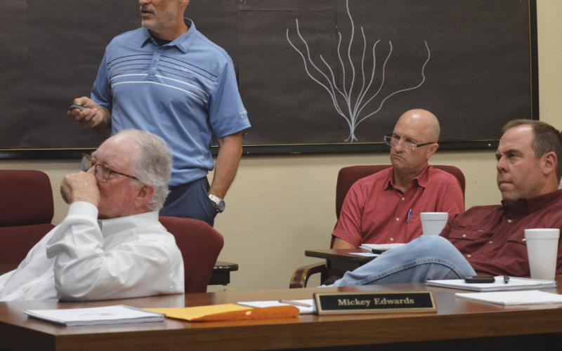Lampasas ISD Assistant Superintendent Dana Holcomb, standing, discusses 2025 STAAR scores during Monday’s Board of Trustees meeting. Trustees also reviewed preliminary budget numbers for fiscal year 2025-2026 with Chief Financial Officer Shane Jones, seated at back. In foreground are board members Mickey Edwards, at left, and Board President Ryan Shahan. erick mitchell | dispatch record