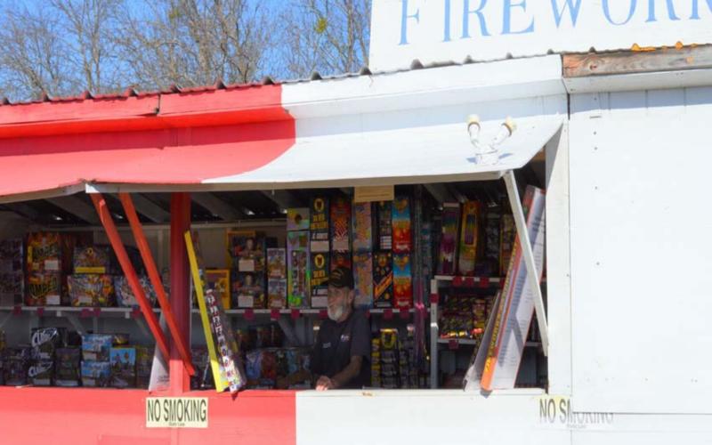 Bob Stewart, owner of Bob’s Discount Fireworks, looks on from inside his stand as he awaits patrons this week. MASON HINES | DISPATCH RECORD