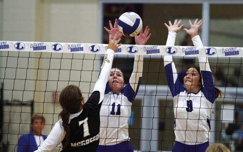 HUNTER KING | DISPATCH RECORD Ava Dowdy, left, and Lilee Hamill jump up for a block. Hamill finished the first game of the season with three blocks.