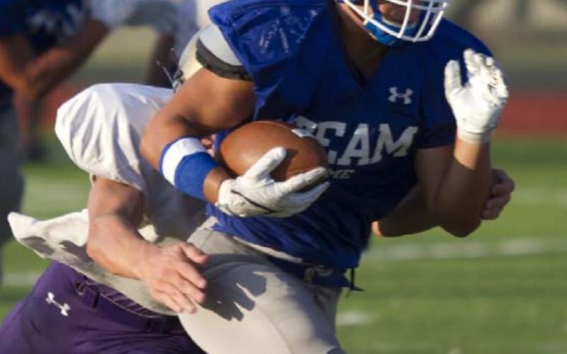 Levi Rivera carries the ball past a Marble Falls defender during the first scrimmage for the Badgers on Friday. HUNTER KING | DISPATCH RECORD