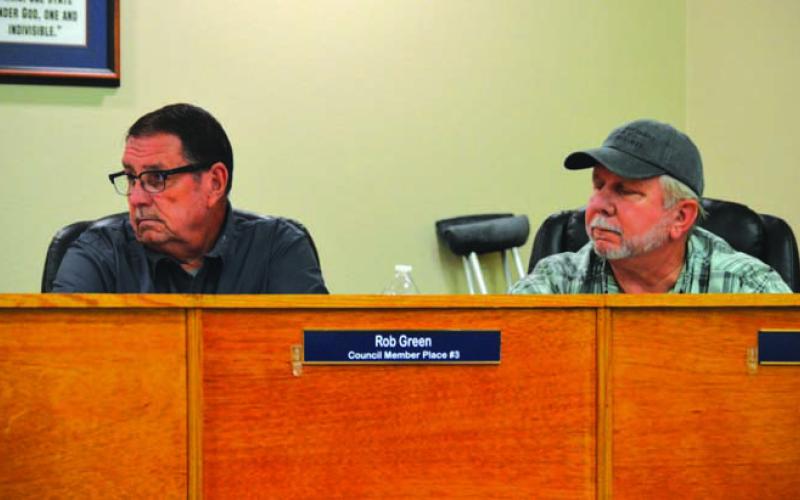 Kempner City Council members Rob Green, left, and Thomas Combs listen as audit information is presented in a council meeting. ERICK MITCHELL | DISPATCH RECORD
