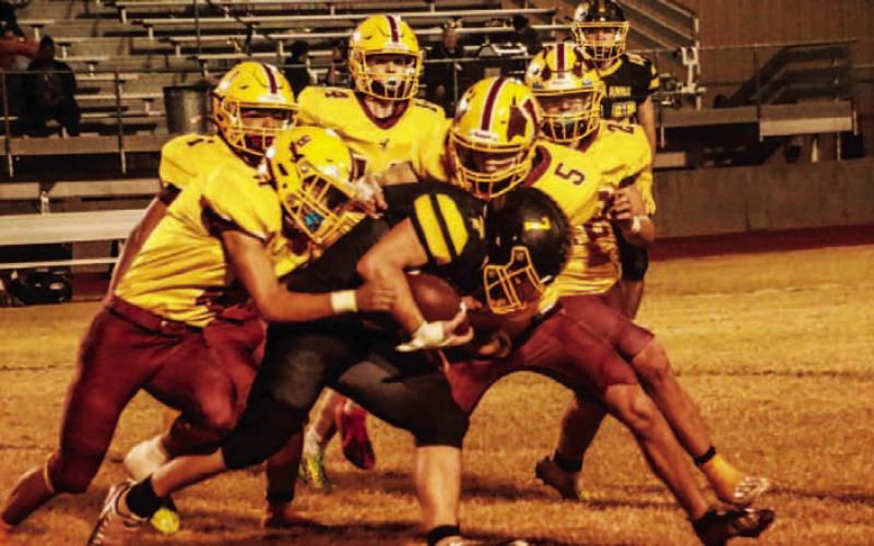 A swarm of Hornets tackle a Mountaineer ball carrier. MEGAN LUSTY | COURTESY PHOTO