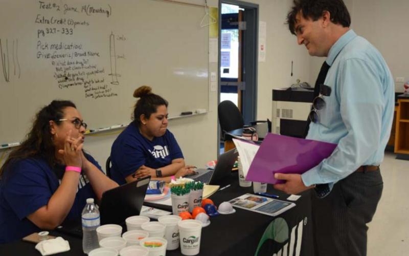 Teresa Gonzalez, left, and Jocelyn Joyas, middle, of Cargill Inc. talk about potential employment opportunities with Copperas Cove resident Fletcher Lenz. MONIQUE BRAND | DISPATCH RECORD