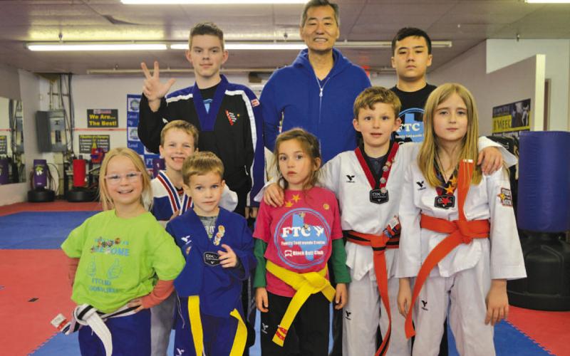 Master Chung Lee, center, stands alongside students from his Lampasas taekwondo studio on Monday. ERICK MITCHELL | DISPATCH RECORD