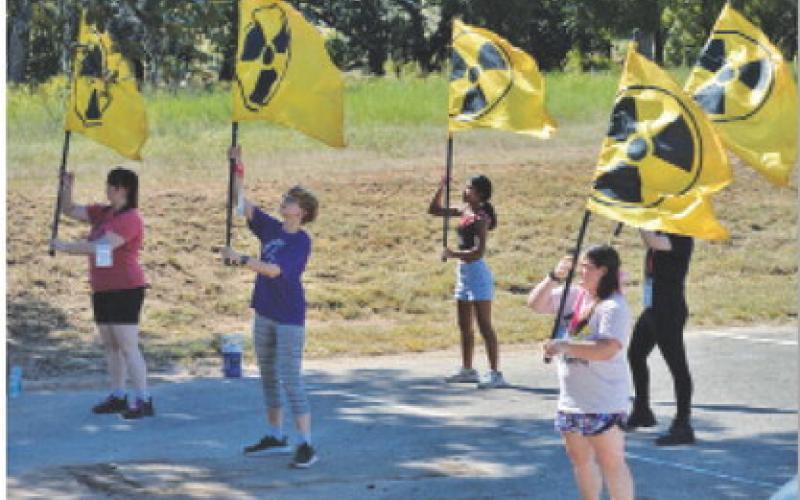 LHS color guard members wave flags with the nuclear symbol, an ode to the nuclear blasts that take place in the “Fallout” universe. ERICK MITCHELL | DISPATCH RECORD