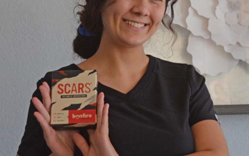 Erin Montgomery poses with her new conversational card game called SCARS. erick mitchell | dispatch record