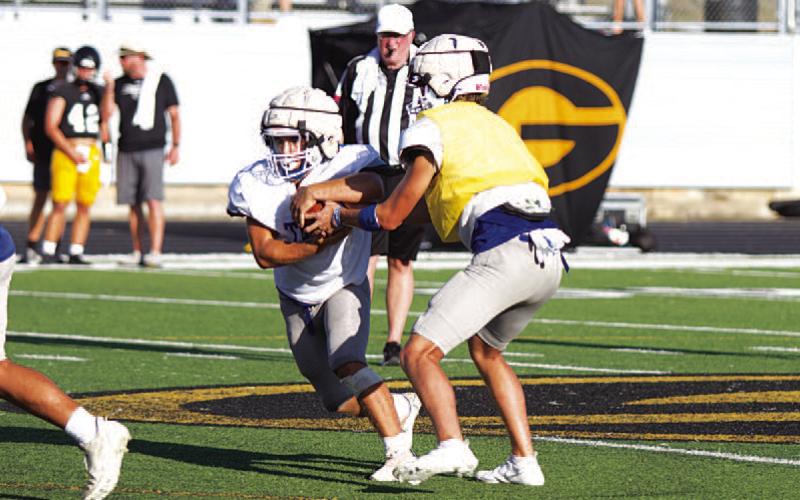 FILE PHOTO Bryson Roberts hands the ball to Daemian Rivas at the Badgers’ first scrimmage last week.
