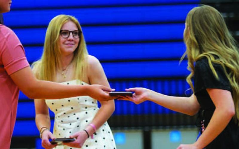 Aspen Wheeler, left, and Addison Borchardt are handed their Hustle awards from coach Brianna Acker. HUNTER KING | DISPATCH RECORD
