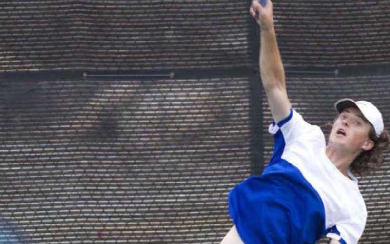 Brendon Burgess hits a serve during the match on Tuesday at the Badger tennis courts. HUNTER KING | DISPATCH RECORD