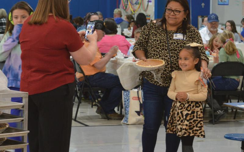 Hanna Springs Elementary School counselor Carisa Brown snaps a photo of Sandra Ceballos and Victoria Garza. Ceballos received a pumpkin pie for making the long trip from Piedras Negras, Mexico, for Thursday’s Grandparents’ Day at the campus. erick Mitchell | dispatch record