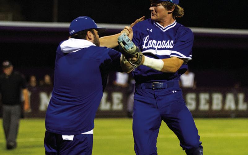 HUNTER KING | DISPATCH RECORD Timber Gholson, right, and assistant coach Jaden Napolez jump together between innings.