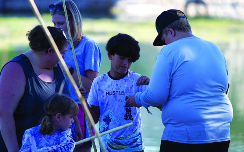 HUNTER KING | DISPATCH RECORD Aiden Norman gets one of his catches measured during the fishing derby.
