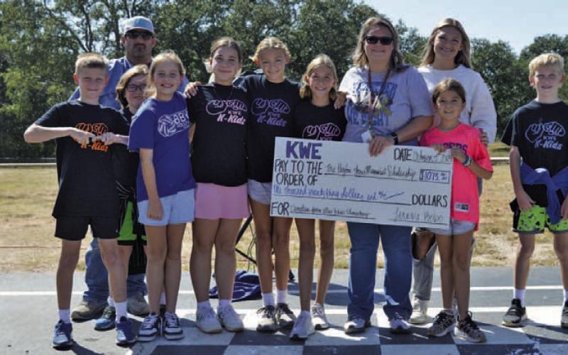 Kline Whitis Elementary School teacher Shante Seward holds a big check for $1,073.62. The funds were raised by Kline Whitis students for the Peyton Jones Memorial Scholarship. Jones, Seward’s son, died after a battle with leukemia several years ago. ERICK MITCHELL | DISPATCH RECORD